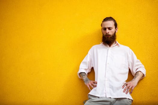 Cool Tattooed bearded hipster on yellow wall