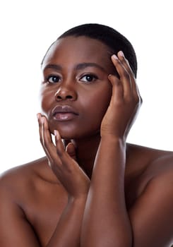 Her skin complexion is amazing. Portrait of a beautiful young woman touching her face while standing against a white background.