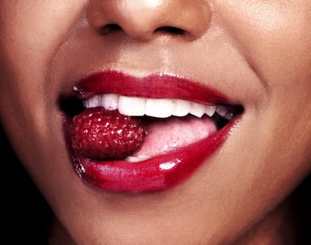 Very berry. an unrecognizable woman posing with a cherry in her mouth.