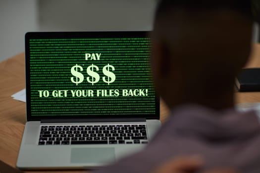 The threat of phishing is real. a businessman using a laptop with the words pay $$$ to get your files back on the screen.