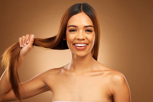 Haircare, smile and portrait of woman with strong hair in hand in studio with texture and shine. Happy model, mockup and beauty, healthy straight hairstyle with keratin product on brown background