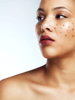What makes you unique makes you beautiful. Studio shot of a beautiful young woman posing with glitter freckles on her face.