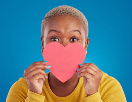 Paper, heart and shy with black woman in studio for love, date and kindness. Invitation, romance and feelings with female and shape isolated on blue background for emotion, support and affectionate