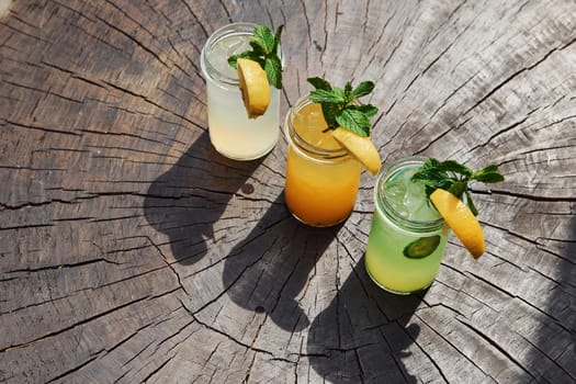 Yellow and green colored. Close up view of fresh summer alcoholic cocktails on the wooden table