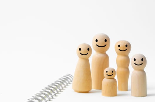 The Happy face on wooden figures of family members. Emotion and satisfaction family concepts.