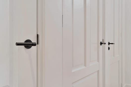 an open white door with a black door knob