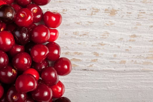 Cherries on wooden table with text space