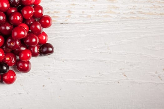 Cherry on white wooden background with copyspace