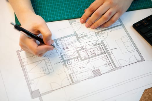 Architect working on blueprints on her table