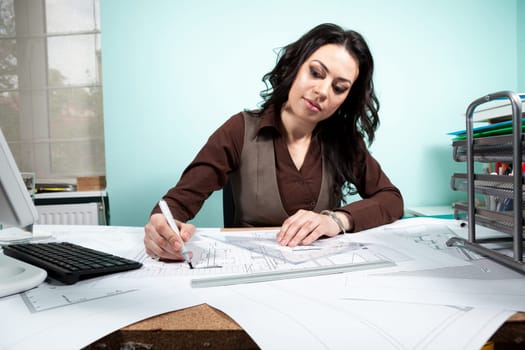 Woman at her working desk with blueprints in front