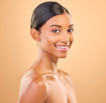Smile, glowing and portrait skincare of a woman isolated on a studio background. Happy, beautiful and an Indian model with a glow from cosmetics, healthy skin and smooth complexion on a backdrop