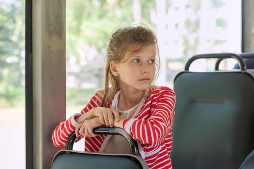 Child passenger of city bus, trolleybus, girl sitting in passenger seat