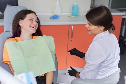 Teenager girl treating teeth at dentist office, consultation of orthodontist dentist