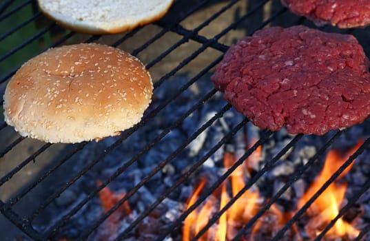Meat burgers and buns for hamburger on fire grill