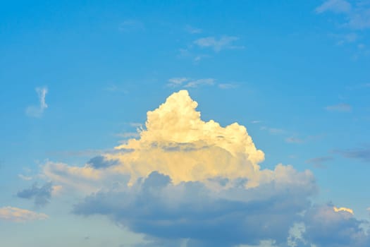 Single bright white dreamlike cloud on a blue dramatic sky