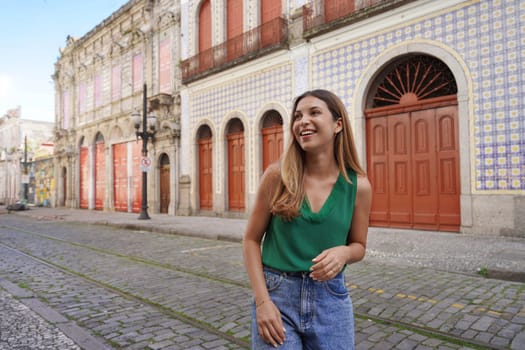 Smiling stylish girl visiting the historic center of Santos, Sao Paulo, Brazil