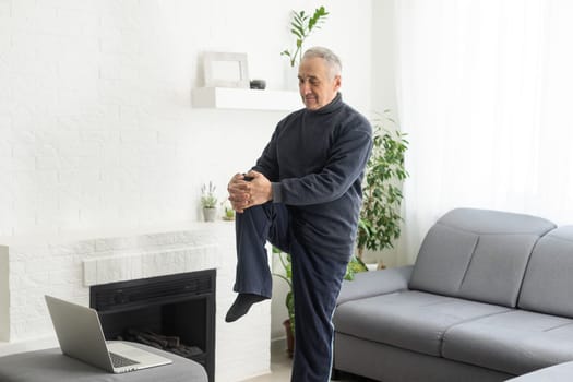 Online workout. elderly man doing exercise with online tutorial at home, panorama, free space