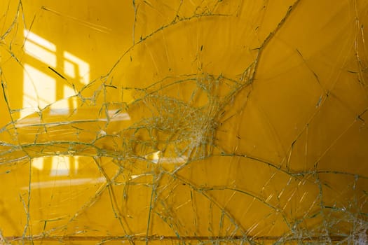 Broken glass standing against a yellow wall in an old abandoned hospital