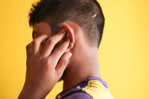 teenage boy having ear pain touching his painful ear ,