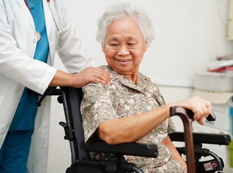 Doctor help Asian elderly woman disability patient sitting on wheelchair in hospital, medical concept.
