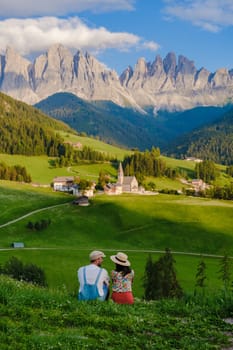 Couple viewing the landscape Italy dolomites Val di Funes in summer, Santa Magdalena village magical Dolomites mountains, Val di Funes valley, Trentino Alto Adige region, South Tyrol, Italy,