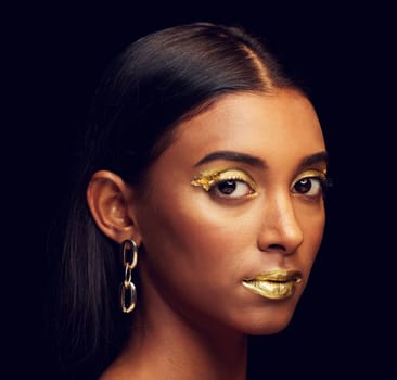 Indian woman, festive makeup and studio portrait for beauty, wellness and celebration by black background. Model, asian girl or dark aesthetic with gold lipstick, jewellery and cosmetics for face art