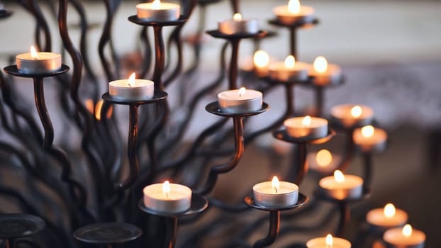 Candlestick holder with burning candles in a Catholic church.