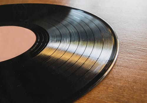 vinyl record lies on brown wooden table