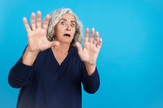 Mature woman gesturing with her hands in fear