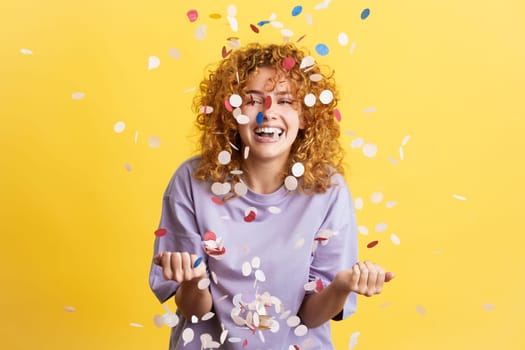Cheerful woman surrounded by confetti in the air