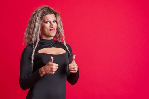 Transgender person with make up gesturing agreement raising thumbs up