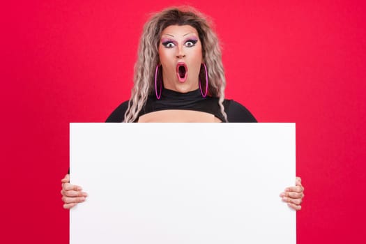 Surprised transgender person holding a blank panel in studio