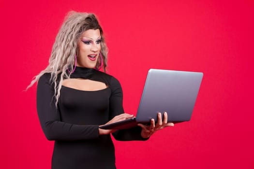 Surprised transgender person standing and using a laptop
