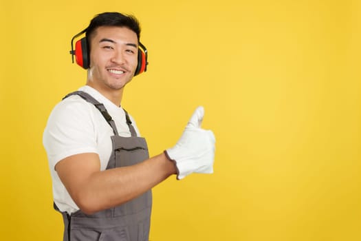 Chinese male carpenter gesturing approval with thumb up