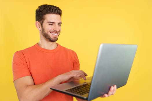 Caucasian man smiling while using a laptop