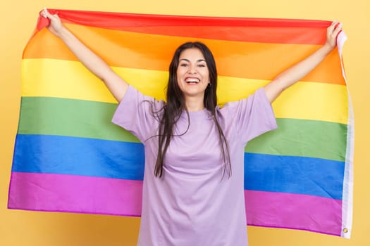Happy caucasian woman raising a lgbt rainbow flag