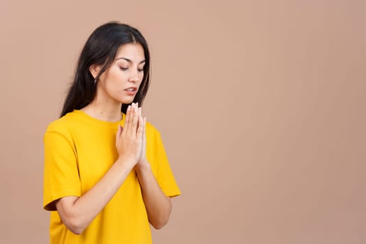 Woman praying with folded hands looking down