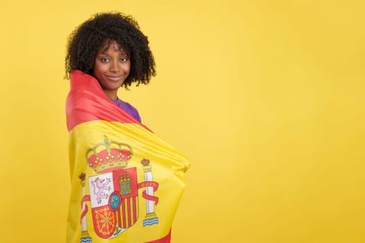 Migrant woman with afro hair wrapped with a Spanish flag