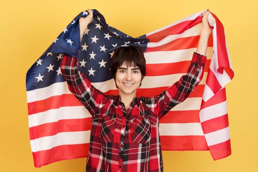 An androgynous person raising a USA flag