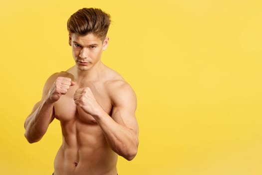Strong male boxer standing with bare torso
