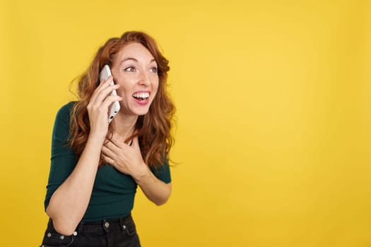 Redheaded woman receiving good news by mobile phone