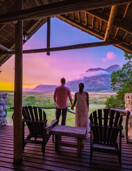 couple man and woman mid age in front of their lodge during vacation in South Africa, Mountains and grassland near Hermanus at the garden route Western Cape South Africa Whale coast