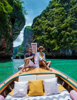 Luxury Longtail boat in Krabi Thailand, couple man and woman on a trip at the tropical island 4 Island trip in Krabi Thailand. Asian woman and European man mid age on vacation in Thailand