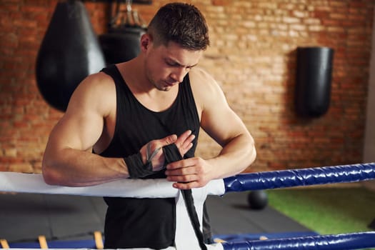 Young boxer in sportive clothes have practice in the gym