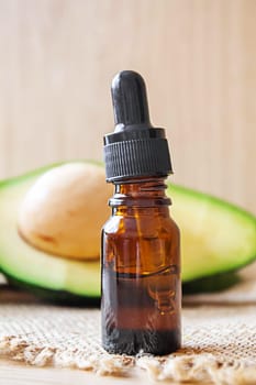 Avocado and avocado oil on wooden background. Selective focus