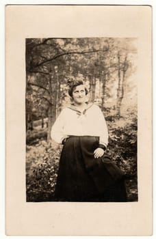 Vintage photo shows woman outside. Retro black and white studio photography with sepia effect.