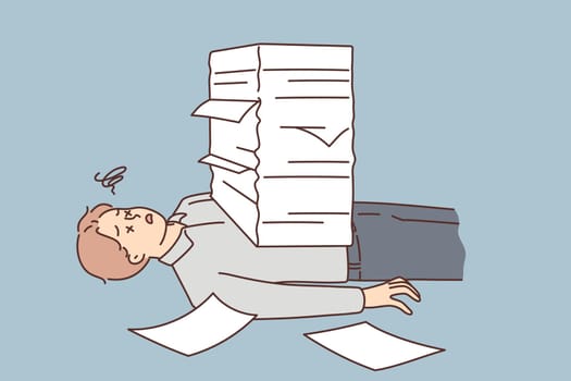Stressed man lying under paperwork pile