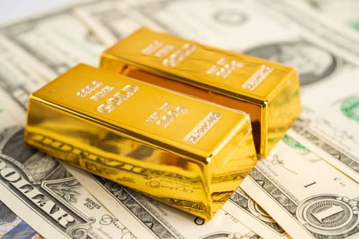 Gold bar on US dollar banknotes money, economy finance exchange trade investment concept. 