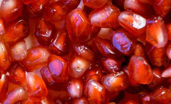 This is a close-up photograph of pomegranate seeds, showing their vibrant red color and texture.