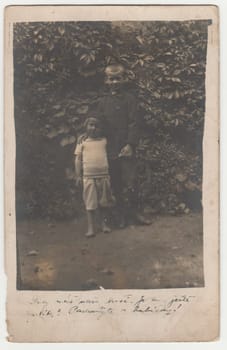 Vintage photo shows two boys - siblings outdoors. Retro black and white photography. Photo was taken in Austro-Hungarian Empire or also Austro-Hungarian Monarchy. Circa 1920s.